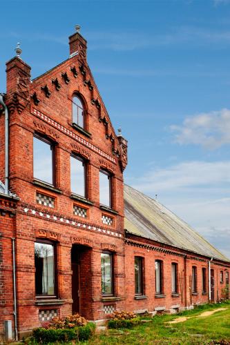 an old red brick building with a roof at Ferien auf Tippen Hof (Bleckede an der Elbe) in Bleckede