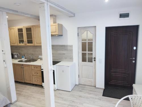 a kitchen with a white refrigerator and a black door at PortStreet apartamenti in Liepāja