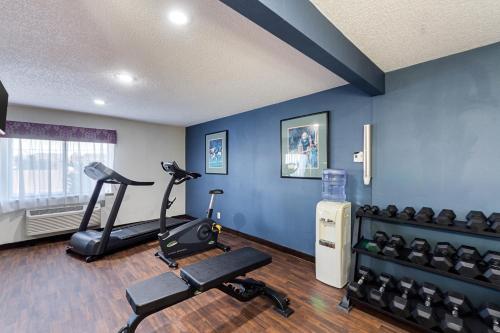 a gym with exercise equipment in a room with blue walls at Comfort Inn Tulsa Midtown in Tulsa