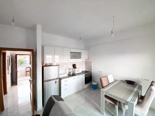 比耶拉的住宿－Apartmani Mili，厨房配有白色橱柜和桌子