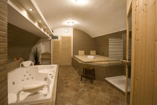 a large bathroom with a tub and a bed at Hotel U Zlatého kohouta in Kroměříž