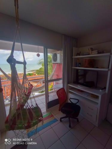 a room with a balcony with a view of the ocean at Village Hospedagens in Natal