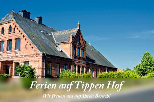 an old red brick building with a black roof at Ferien auf Tippen Hof (Bleckede an der Elbe) in Bleckede