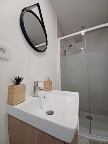 a bathroom with a white sink and a mirror at Mazamet - Studio neuf et moderne en centre-ville in Mazamet