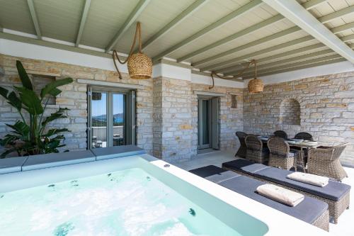 a large pool in a patio with a table and chairs at Sersi Paros Villas & Suites in Kampos Paros