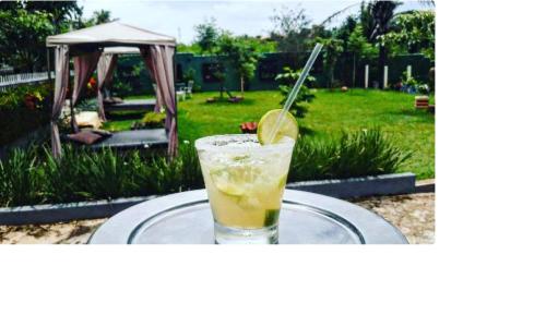 a drink on a glass plate on a table in a yard at Pousada Vila do Mar in São Luís