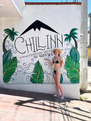 een vrouw in bikini die voor een muurschildering staat bij The Chill in Mansion Hostel Santa Marta in Santa Marta