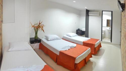 Habitación con 2 camas y espejo. en Hotel San Lorenzo en Bucaramanga