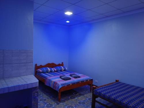 um quarto azul com uma cama e um banco em Sky Beach Hotel em Catmon