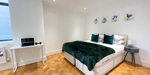a bedroom with a bed and a laptop on a table at Beautiful Apartment In The Heart of Chelmsford in Chelmsford