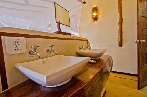 a bathroom with two sinks on a wooden counter at Casa Cabana Beach in Vilanculos