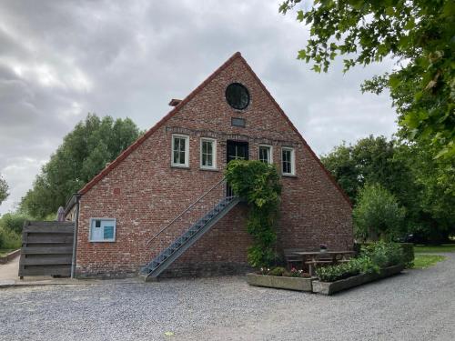 a red brick building with a staircase on it at 't Uilengat 6-8 persoons appartement in Retranchement