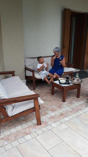 two women and a baby sitting on benches in a room at Maryhouse in Borso del Grappa