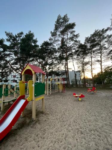 a playground with a slide in the sand at Apartament Jantar in Jantar