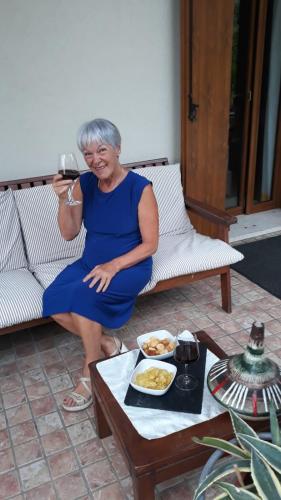 a woman sitting on a couch holding a glass of wine at Maryhouse in Borso del Grappa