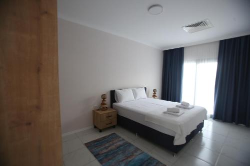 a bedroom with a white bed and a window at Talia Villalari in Fethiye