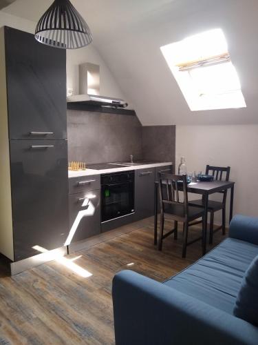 Il dispose d'une cuisine avec une table et une cuisinière. dans l'établissement LE MARCEL appartement F1 de 24 m², à Choisey