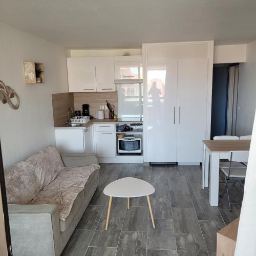 un salon avec un canapé et une table dans l'établissement Superbe appartement avec piscine, au Barcarès