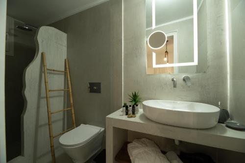a bathroom with a white sink and a toilet at Villa Echedra in Vlychada