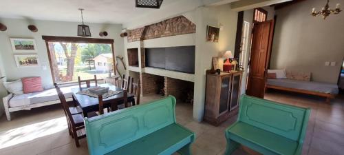 ein Wohnzimmer mit Tisch und Stühlen und einem Kamin in der Unterkunft las brisas casas de campo un lugar para soñar in San Antonio de Arredondo