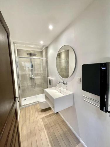 ein Bad mit einem Waschbecken, einer Dusche und einem Spiegel in der Unterkunft NEW, La Passante, Belle vue in Conques-sur-Orbiel