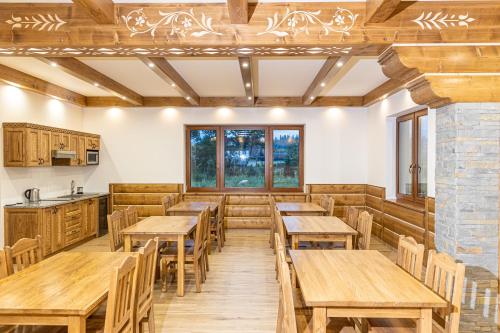 uma sala de jantar com mesas e cadeiras de madeira em Willa Taterniok - pokoje z widokiem na Tatry em Czarna Góra