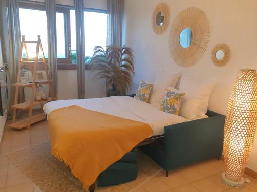 um quarto com uma cama num quarto com janelas em Charmant studio vue mer / parking / plage à 200m em Bastia