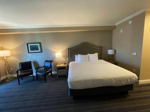 a hotel room with a bed and two chairs at Majestic Inn and Spa in Anacortes
