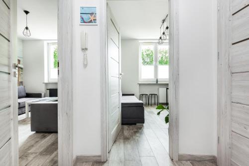 un pasillo con paredes blancas y suelo de madera en Apartament Nadia, en Gdynia