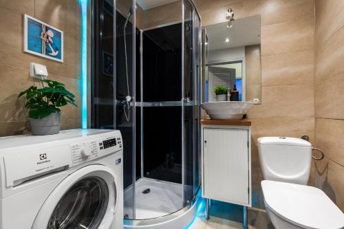 ein Badezimmer mit einer Waschmaschine und einem WC in der Unterkunft Apartament Nadia in Gdynia
