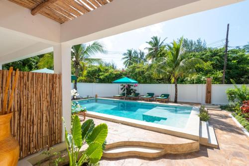 a swimming pool in the backyard of a house at Daima Villas in Jambiani