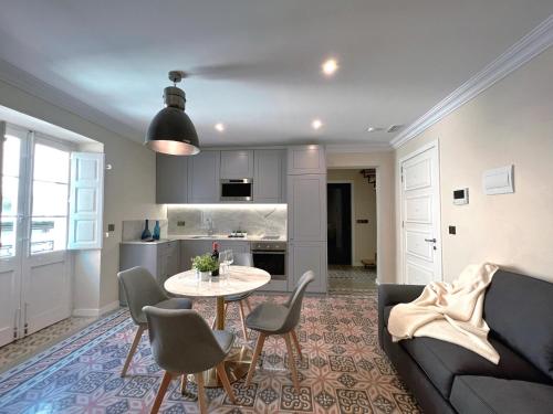 a living room with a table and chairs and a kitchen at Independence MALTA APARTMENTS in Valletta