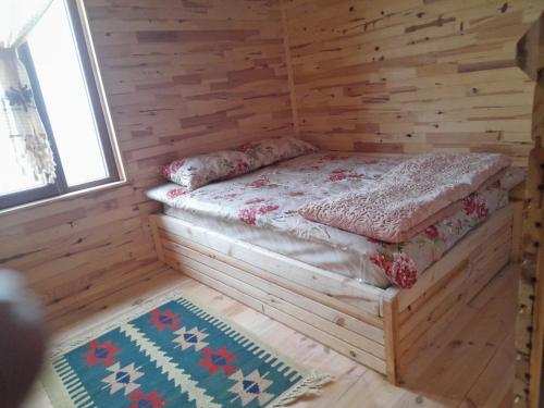 um quarto com uma cama num chalé de madeira em Erdal Pansiyon em Çamlıhemşin