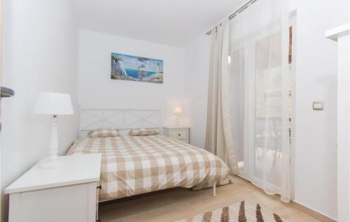 een witte slaapkamer met een bed en een raam bij I & M Guest House in Banjole