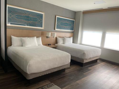 a hotel room with two beds and a window at Hyatt Place Tulsa/Downtown in Tulsa