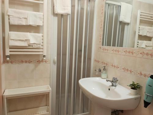 a white bathroom with a sink and a mirror at Affittacamere Elisa in Pisa