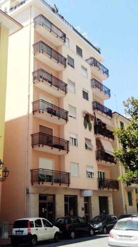 a building with balconies and cars parked in front of it at Affittacamere L'Orchidea in Ventimiglia