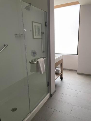 a bathroom with a shower with a glass door at Hyatt Place Tulsa/Downtown in Tulsa
