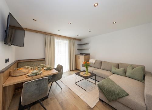 a living room with a couch and a table at Lenni´s Apartments in Bruck an der Großglocknerstraße