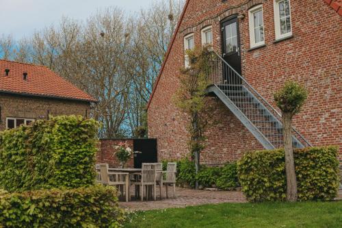 a brick building with a staircase on the side of it at de Kafzolder 6-8 persoons appartement in Retranchement