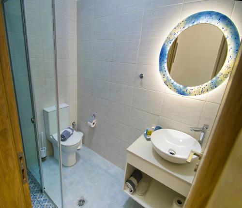 a bathroom with a sink and a mirror and a toilet at Petite palace in Rethymno Town