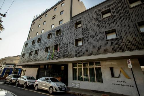 two cars parked in front of a building at LA HOTEL VOTUPORANGA in Votuporanga