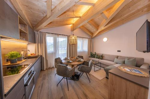 Lenni´s Apartments في بروك آن دير غروسغلوكنرشتراسه: مطبخ وغرفة معيشة مع طاولة وأريكة