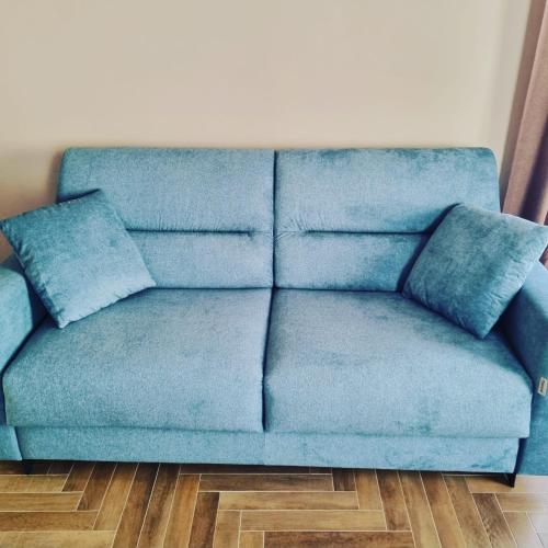 a blue couch sitting in a living room at Palazzo Sarti Suites in Rodi Garganico