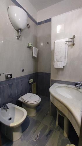 a bathroom with a white sink and a toilet at Hotel Paradiso in Lago Patria