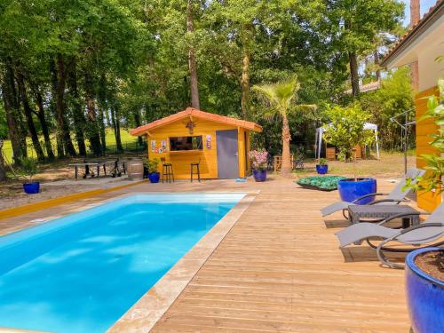 a swimming pool with a gazebo next to a house at Magnifique villa avec piscine in Biscarrosse