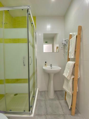 a bathroom with a glass shower and a sink at Douro sunset lounge in Porto