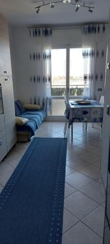 uma sala de estar com um sofá e uma mesa em APPARTAMENTO IN SOTTOMARINA DI CHIOGGIA em Chioggia