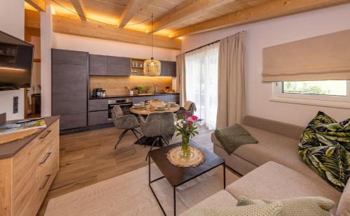Lenni´s Apartments في بروك آن دير غروسغلوكنرشتراسه: مطبخ وغرفة معيشة مع أريكة وطاولة