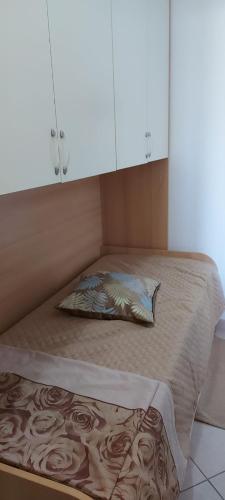 uma cama num quarto com uma almofada em APPARTAMENTO IN SOTTOMARINA DI CHIOGGIA em Chioggia
